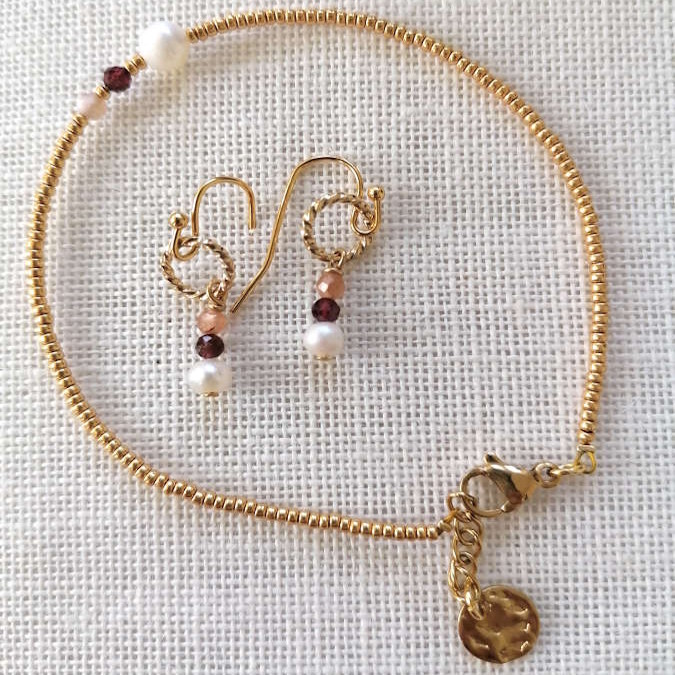 Armbånd og øreringe, Et elegant gyldent sæt med små perledetaljer, hvor armbåndets enkle linje får et legende modspil af de matchende øreringe.